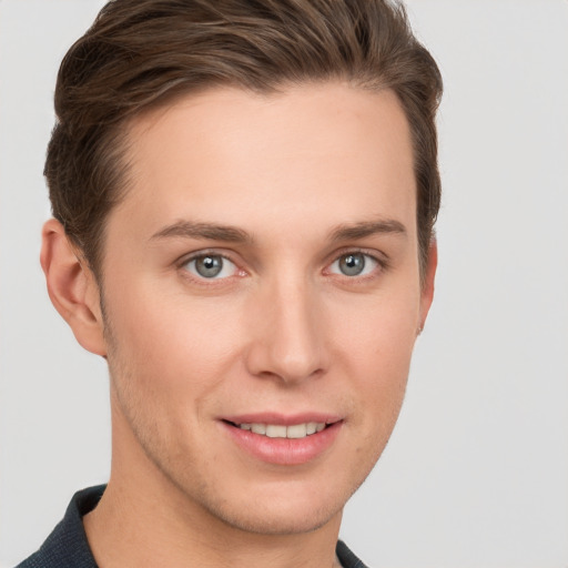 Joyful white young-adult male with short  brown hair and grey eyes