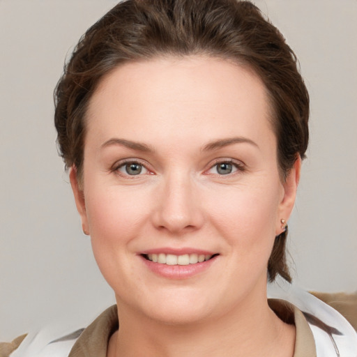 Joyful white young-adult female with short  brown hair and grey eyes