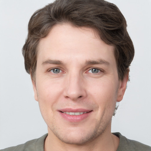 Joyful white young-adult male with short  brown hair and grey eyes