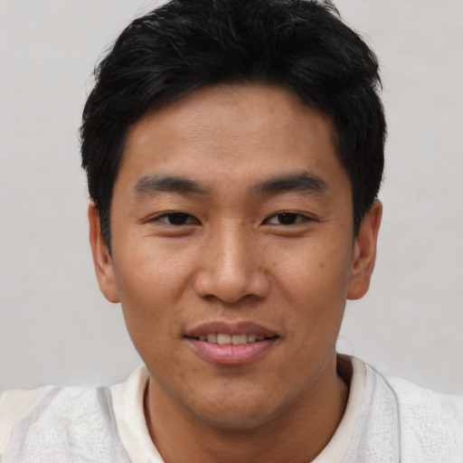 Joyful asian young-adult male with short  black hair and brown eyes