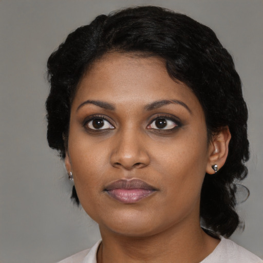Joyful black young-adult female with medium  brown hair and brown eyes
