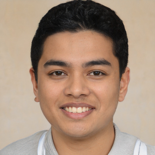 Joyful latino young-adult male with short  black hair and brown eyes