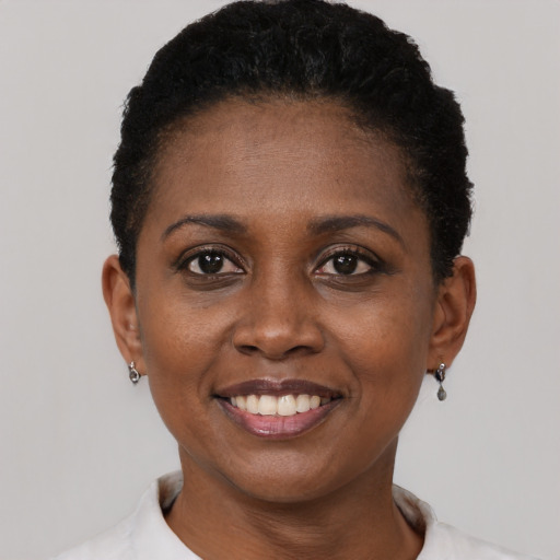 Joyful black young-adult female with short  black hair and brown eyes