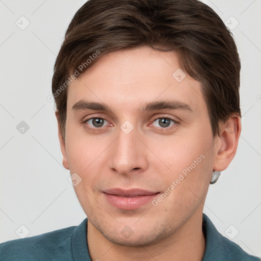 Joyful white young-adult male with short  brown hair and grey eyes