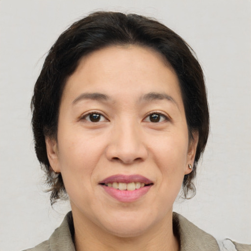 Joyful asian adult female with medium  brown hair and brown eyes