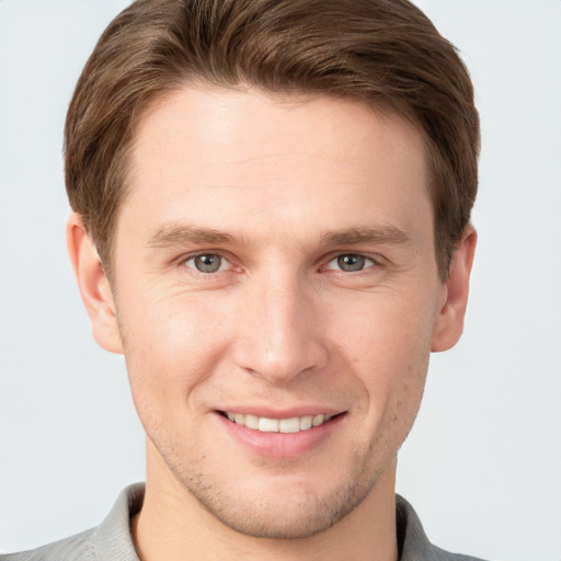 Joyful white young-adult male with short  brown hair and grey eyes