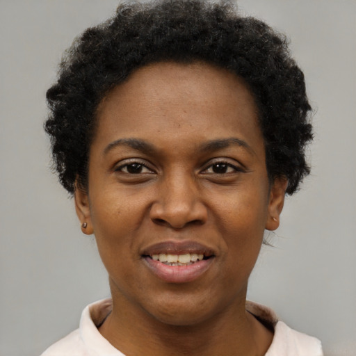 Joyful black adult female with short  black hair and brown eyes
