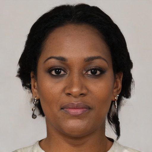 Joyful black young-adult female with medium  black hair and brown eyes