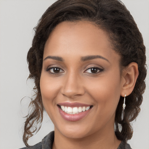 Joyful latino young-adult female with long  brown hair and brown eyes