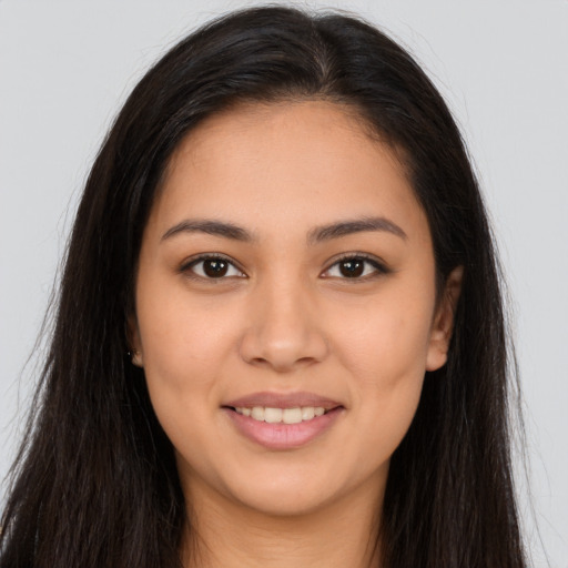 Joyful latino young-adult female with long  brown hair and brown eyes