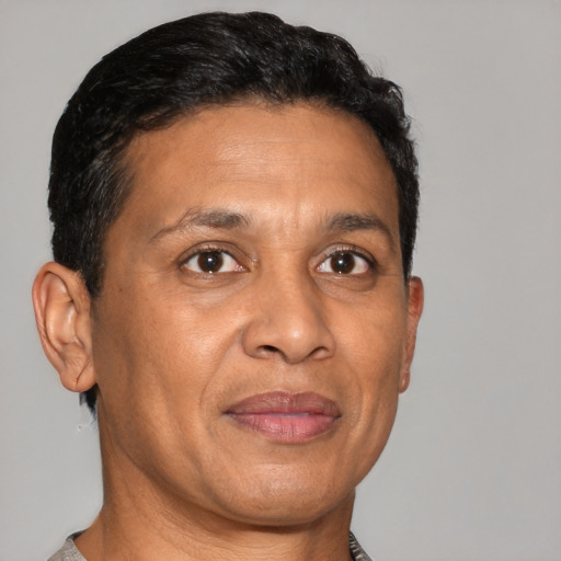 Joyful latino adult male with short  brown hair and brown eyes