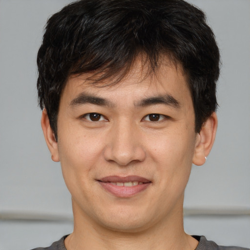 Joyful asian young-adult male with short  brown hair and brown eyes