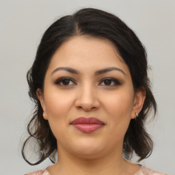 Joyful latino young-adult female with medium  brown hair and brown eyes