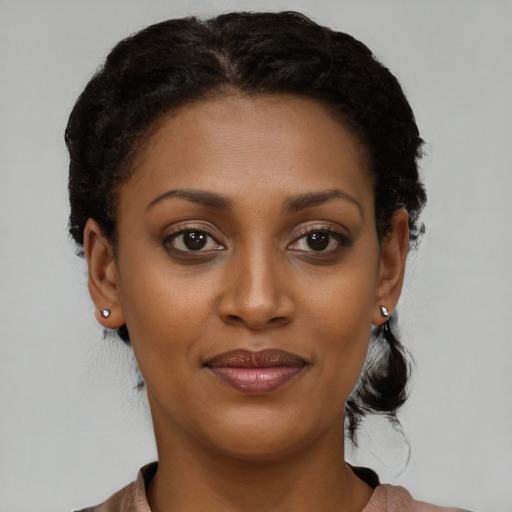 Joyful black young-adult female with short  brown hair and brown eyes