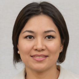 Joyful asian young-adult female with medium  brown hair and brown eyes