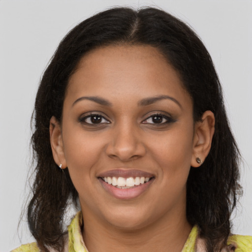 Joyful black young-adult female with long  brown hair and brown eyes