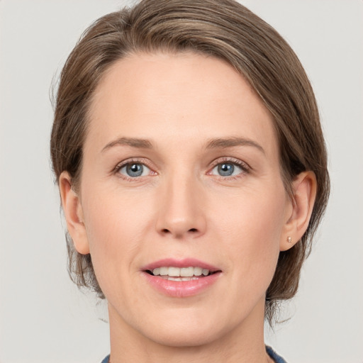 Joyful white adult female with medium  brown hair and grey eyes