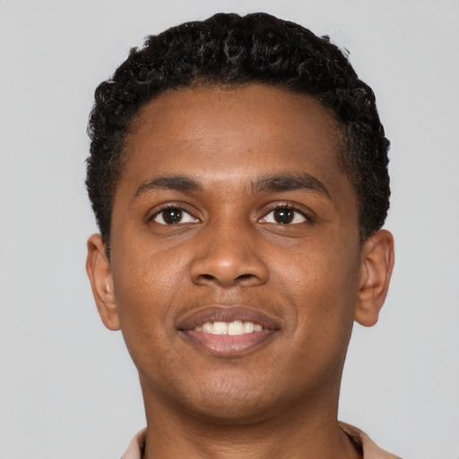 Joyful black young-adult male with short  brown hair and brown eyes