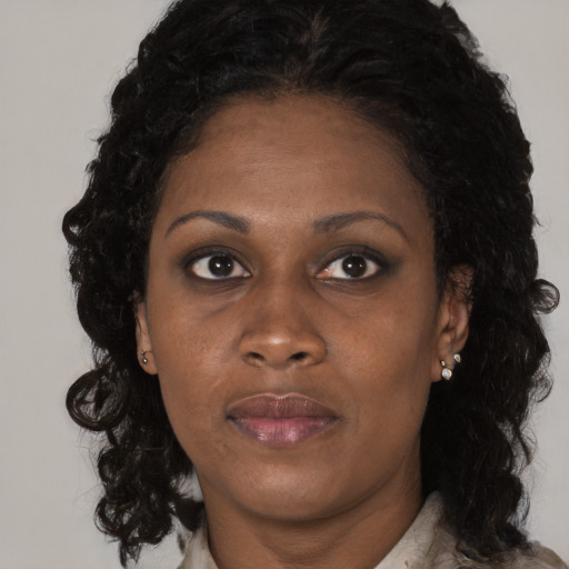 Joyful black young-adult female with long  brown hair and brown eyes