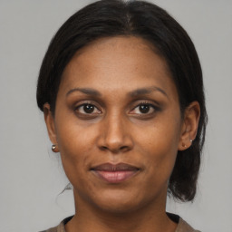 Joyful black adult female with medium  brown hair and brown eyes