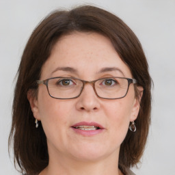 Joyful white adult female with medium  brown hair and grey eyes