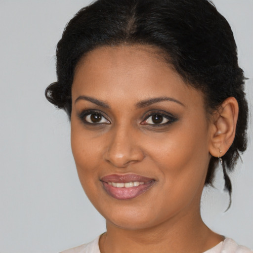 Joyful black young-adult female with medium  brown hair and brown eyes
