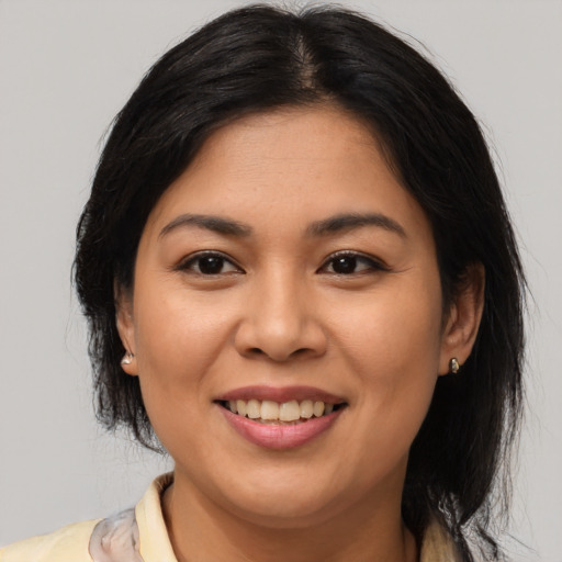 Joyful latino young-adult female with medium  brown hair and brown eyes