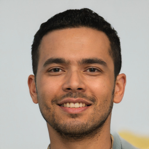 Joyful latino young-adult male with short  black hair and brown eyes