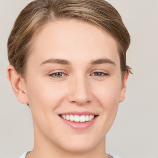 Joyful white young-adult female with short  brown hair and grey eyes