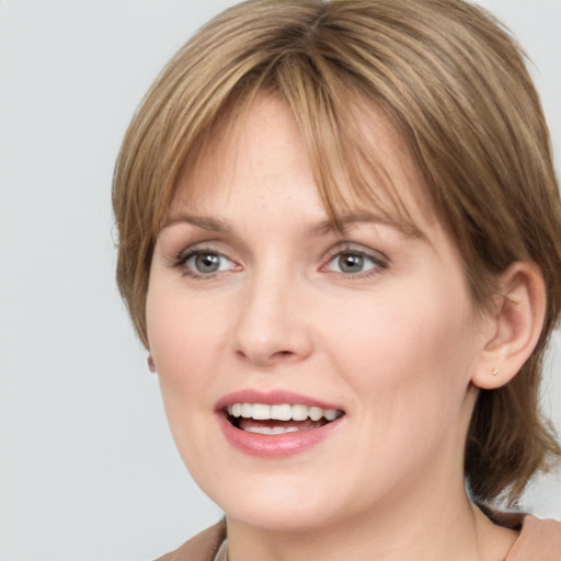 Joyful white young-adult female with medium  brown hair and grey eyes