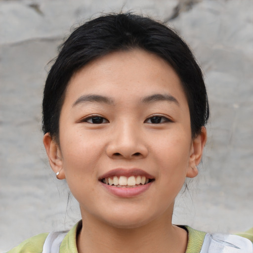 Joyful asian young-adult female with short  brown hair and brown eyes