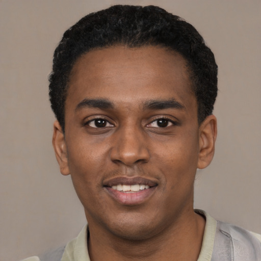 Joyful black young-adult male with short  black hair and brown eyes