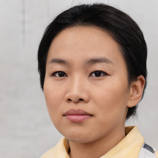 Joyful asian young-adult female with short  brown hair and brown eyes