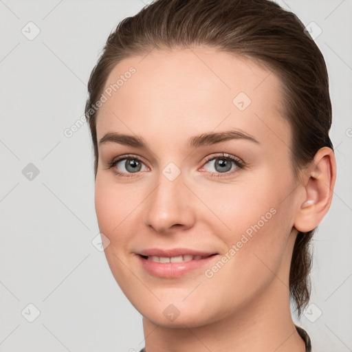 Joyful white young-adult female with medium  brown hair and grey eyes