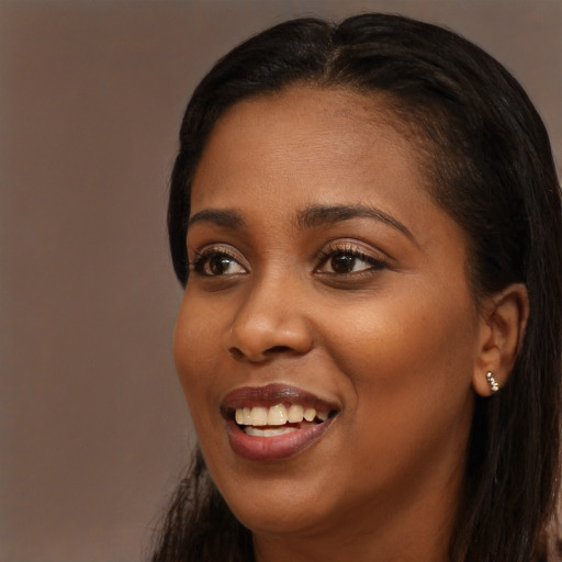 Joyful black young-adult female with long  brown hair and brown eyes