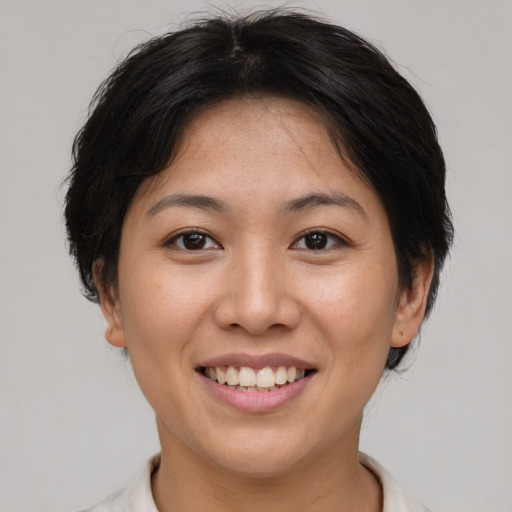 Joyful asian young-adult female with short  brown hair and brown eyes