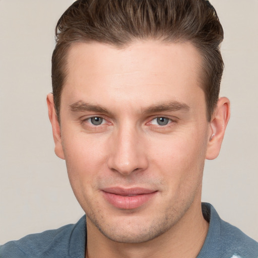 Joyful white young-adult male with short  brown hair and grey eyes