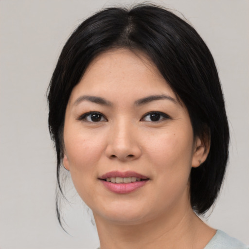 Joyful asian young-adult female with medium  black hair and brown eyes
