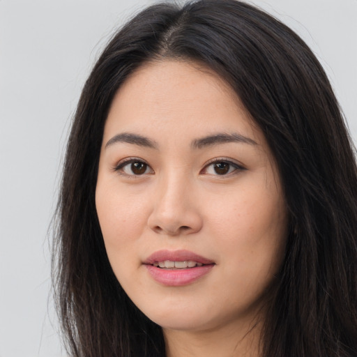 Joyful asian young-adult female with long  brown hair and brown eyes