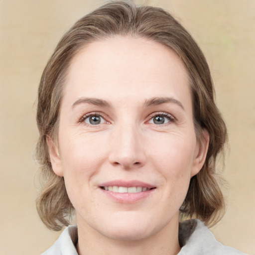 Joyful white young-adult female with medium  brown hair and green eyes