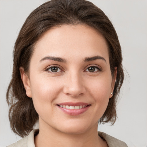 Joyful white young-adult female with medium  brown hair and grey eyes