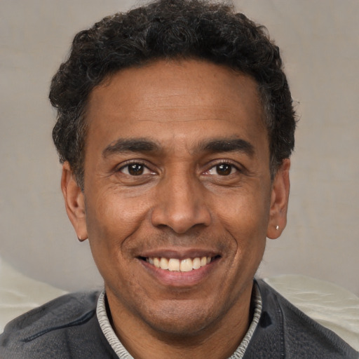 Joyful latino adult male with short  black hair and brown eyes