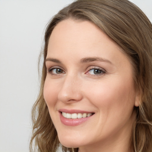 Joyful white young-adult female with long  brown hair and blue eyes