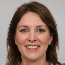 Joyful white adult female with medium  brown hair and grey eyes