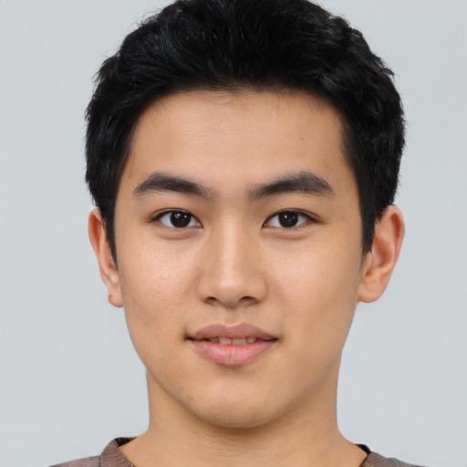 Joyful asian young-adult male with short  black hair and brown eyes