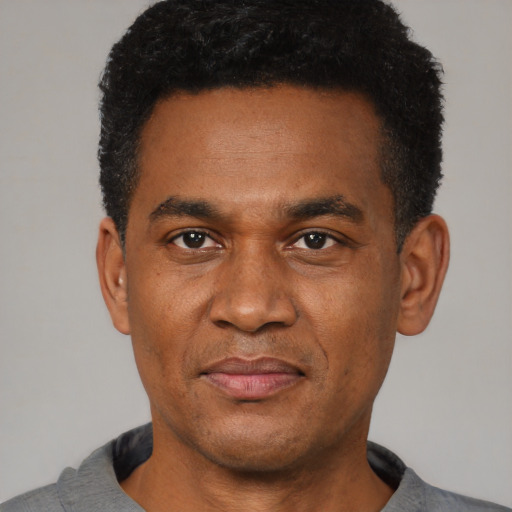 Joyful latino adult male with short  black hair and brown eyes