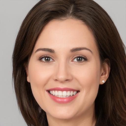 Joyful white young-adult female with long  brown hair and brown eyes