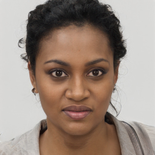 Joyful black young-adult female with short  black hair and brown eyes