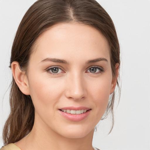 Joyful white young-adult female with medium  brown hair and grey eyes