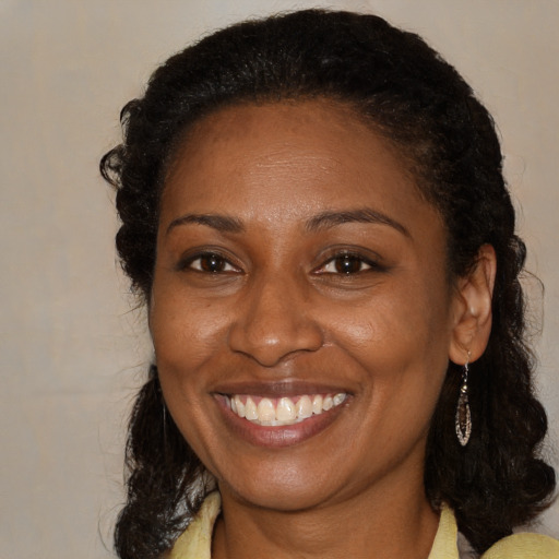 Joyful black young-adult female with medium  brown hair and brown eyes